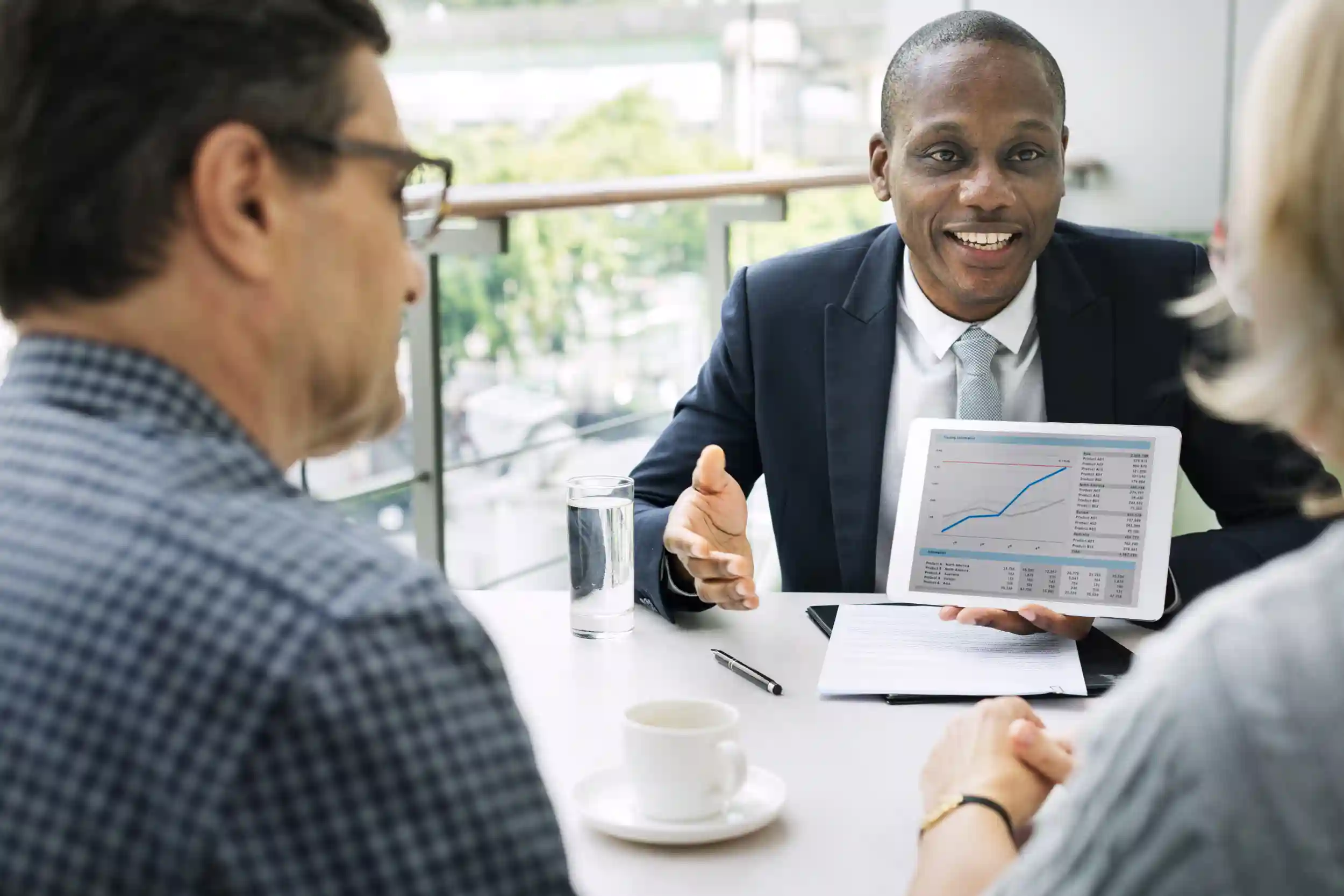 Man presenting a graph on a tablet to clients.